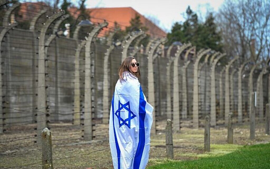 Une jeune femme enveloppée dans un drapeau israélien lors de la Marche des vivants au camp d'Auschwitz-Birkenau en Pologne, le 11 avril 2018. (Yossi Zeliger/Flash90)