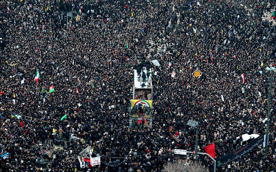 Les cercueils du général Qassem Soleimani et des Iraniens tués en Irak par une frappe de drones américains sont transportés dans un camion entouré de citoyens en deuil, lors d'un cortège funèbre dans la ville de Mashhad, en Iran, le 5 janvier 2020. (Crédit : Mohammad Hossein Thaghi / Tasnim News Agence via AP)