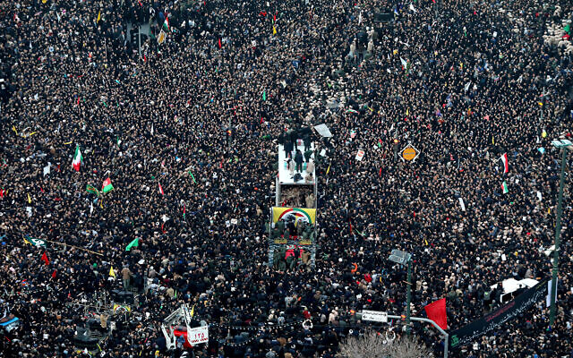 Les cercueils du général Qassem Soleimani et des Iraniens tués en Irak par une frappe de drones américains sont transportés dans un camion entouré de citoyens en deuil, lors d'un cortège funèbre dans la ville de Mashhad, en Iran, le 5 janvier 2020. (Crédit : Mohammad Hossein Thaghi / Tasnim News Agence via AP) Les cercueils du général Qassem Soleimani et des Iraniens tués en Irak par une frappe de drones américains sont transportés dans un camion entouré de citoyens en deuil, lors d'un cortège funèbre dans la ville de Mashhad, en Iran, le 5 janvier 2020. (Crédit : Mohammad Hossein Thaghi / Tasnim News Agence via AP)
