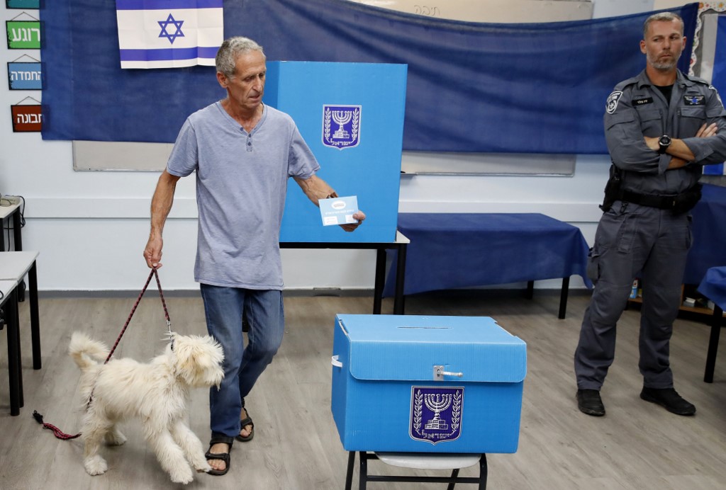 Un homme avec son chien vote dans un bureau de Rosh Haayin, le 17 septembre 2019 (Crédit : Jack GUEZ / AFP) Un homme avec son chien vote dans un bureau de Rosh Haayin, le 17 septembre 2019 (Crédit : Jack GUEZ / AFP)