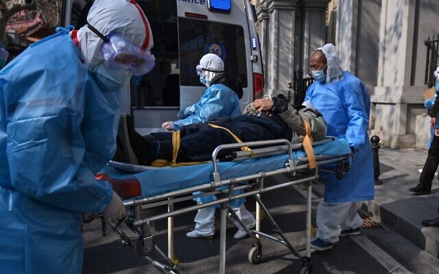 Des personnels médicaux en habit de protection transportent un patient depuis son appartement soupçonné d'être atteint par le virus à Wuhan, le 30 janvier 2020 (Crédit : Hector RETAMAL / AFP) Des personnels médicaux en habit de protection transportent un patient depuis son appartement soupçonné d'être atteint par le virus à Wuhan, le 30 janvier 2020 (Crédit : Hector RETAMAL / AFP)