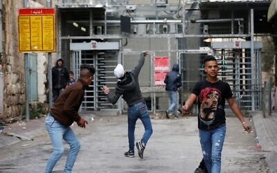 Des manifestants palestiniens lancent des pierres à un point de contrôle israélien lors d'affrontements avec les soldats israéliens dans le centre de la ville poudrière d'Hébron en Cisjordanie le 4 février 2020. (Photo par HAZEM BADER / AFP) Des manifestants palestiniens lancent des pierres à un point de contrôle israélien lors d'affrontements avec les soldats israéliens dans le centre de la ville poudrière d'Hébron en Cisjordanie le 4 février 2020. (Photo par HAZEM BADER / AFP)