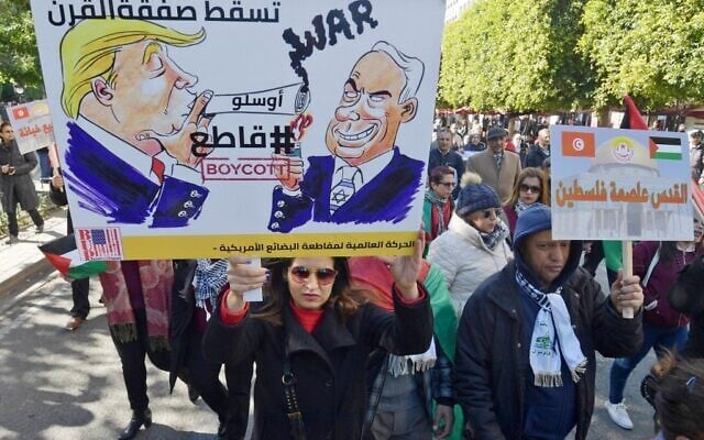 Des manifestants tunisiens brandissent des pancartes contre la proposition de plan de paix du Moyen-Orient du président américain Donald Trump lors d'une manifestation le 5 février 2020 à Tunis. L'écriture arabe sur des pancartes se lit comme suit : "Jérusalem est la capitale de la Palestine" (d) et "A bas l'accord du siècle", #Boycott" à côté d'images de caricatures de Trump et du Premier ministre israélien Benjamin Netanyahu. (Crédit : FETHI BELAID / AFP) Des manifestants tunisiens brandissent des pancartes contre la proposition de plan de paix du Moyen-Orient du président américain Donald Trump lors d'une manifestation le 5 février 2020 à Tunis. L'écriture arabe sur des pancartes se lit comme suit : "Jérusalem est la capitale de la Palestine" (d) et "A bas l'accord du siècle", #Boycott" à côté d'images de caricatures de Trump et du Premier ministre israélien Benjamin Netanyahu. (Crédit : FETHI BELAID / AFP)