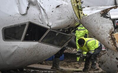 Un employé de la compagnie aérienne turque Pegasus inspecte l'épave du Boeing 737 qui est sorti de la piste et s'est brisé en trois parties lors de son atterrissage à l'aéroport Sabiha Gokcen, à Istanbul, le 6 février 2020. (Crédit : Ozan KOSE / AFP)