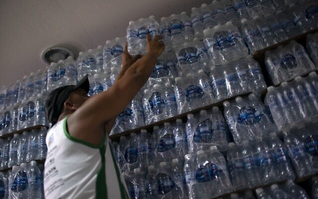 Un homme achète de l'eau en bouteille dans un magasin d'alcool du quartier de Lapa à Rio de Janeiro, le 15 janvier 2020. (Crédit : Mauro Pimentel / AFP) Un homme achète de l'eau en bouteille dans un magasin d'alcool du quartier de Lapa à Rio de Janeiro, le 15 janvier 2020. (Crédit : Mauro Pimentel / AFP)