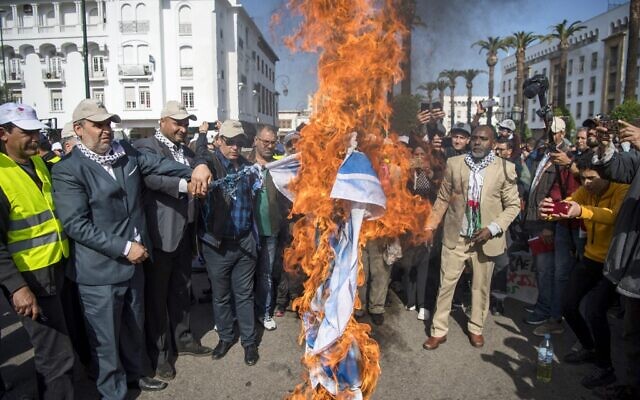 Des Marocains brûlent le drapeau israélien lors d'une manifestation contre le plan de paix américain pour le Moyen Orient dans la capitale Rabat, le 9 février 2020. (Crédit : FADEL SENNA / AFP) Des Marocains brûlent le drapeau israélien lors d'une manifestation contre le plan de paix américain pour le Moyen Orient dans la capitale Rabat, le 9 février 2020. (Crédit : FADEL SENNA / AFP)