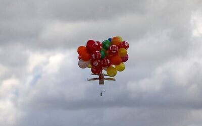 Des ballons transportent un dispositif incendiaire après avoir été lancés depuis le camp de réfugiés de Bureij, à Gaza, le long de la clôture entre Israël et Gaza, le 10 février 2020. (Crédit : MAHMUD HAMS / AFP)