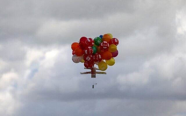 Des ballons transportent un dispositif incendiaire après avoir été lancés depuis le camp de réfugiés de Bureij, à Gaza, le long de la clôture entre Israël et Gaza, le 10 février 2020. (Crédit : MAHMUD HAMS / AFP)