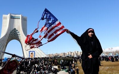 Une femme iranienne brandit un drapeau américain brûlé lors des commémorations marquant les 41 ans de la Révolution islamique sur la place Azadi, à Téhéran, le 11 février 2020. (Crédit : Atta KENARE / AFP) Une femme iranienne brandit un drapeau américain brûlé lors des commémorations marquant les 41 ans de la Révolution islamique sur la place Azadi, à Téhéran, le 11 février 2020. (Crédit : Atta KENARE / AFP)