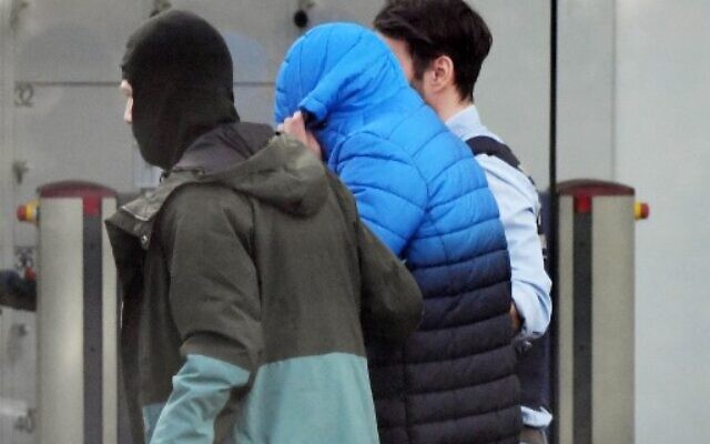 Des policiers transportant un suspect soupçonné d'être l'un des douze hommes arrêtés la veille dans le cadre d'une enquête nationale sur une cellule d'extrême droite, à son arrivée à la Cour suprême fédérale (Bundesgerichtshof) à Karlsruhe, dans le sud de l'Allemagne, le 15 février 2020. (Crédit : Uli Deck / DPA / AFP) Des policiers transportant un suspect soupçonné d'être l'un des douze hommes arrêtés la veille dans le cadre d'une enquête nationale sur une cellule d'extrême droite, à son arrivée à la Cour suprême fédérale (Bundesgerichtshof) à Karlsruhe, dans le sud de l'Allemagne, le 15 février 2020. (Crédit : Uli Deck / DPA / AFP)