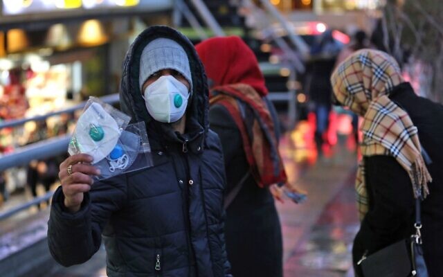 Un Iranien vend des masques de protection, à Téhéran le 20 février 2020. (Crédit : ATTA KENARE / AFP)