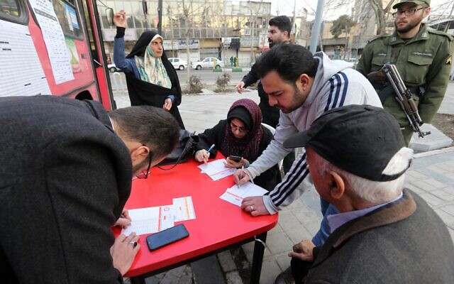 Un Iranien s'inscrit pour voter dans un bureau de vote mobile dans la capitale Téhéran le 21 février 2020. (Crédit : ATTA KENARE / AFP)
