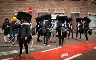 Des carnavaliers déguisés en Juifs ultra-orthodoxes avant le début du Carnaval d'Alost le 23 février 2020, Alost, Belgique. (Crédit : JAMES ARTHUR GEKIERE / AFP)