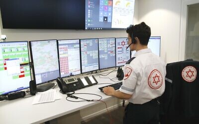 Des standardistes de la Magen David Adom répondent aux questions d'Israéliens inquiets de la propagation du nouveau coronavirus, à Kiryat Ono, le 26 février 2020. (Crédit : JACK GUEZ / AFP)