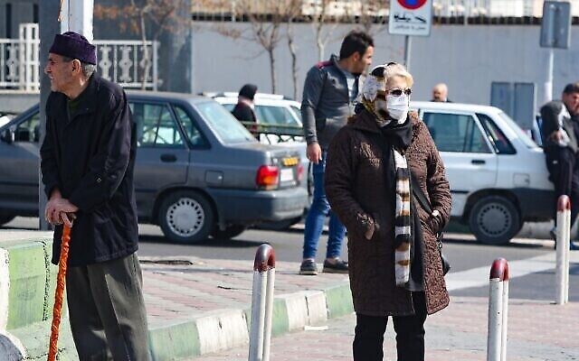 Une Iranienne portant un masque de protection et des gants, dans une rue animée de la capitale Téhéran, le 22 février 2020. (Crédit : ATTA KENARE / AFP) Une Iranienne portant un masque de protection et des gants, dans une rue animée de la capitale Téhéran, le 22 février 2020. (Crédit : ATTA KENARE / AFP)
