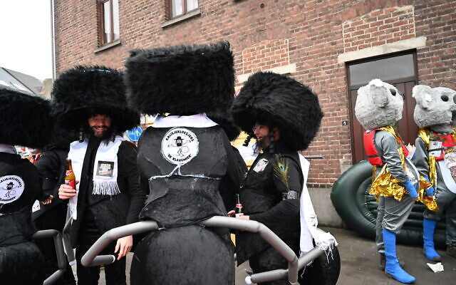 Des participants du carnaval d'Alost portant des costumes associant des vêtements juifs ultra-orthodoxes à des pattes de fourmis lors de l'événement à Alost, en Belgique, le 23 février 2020. (Cnaan Liphshiz) Des participants du carnaval d'Alost portant des costumes associant des vêtements juifs ultra-orthodoxes à des pattes de fourmis lors de l'événement à Alost, en Belgique, le 23 février 2020. (Cnaan Liphshiz)