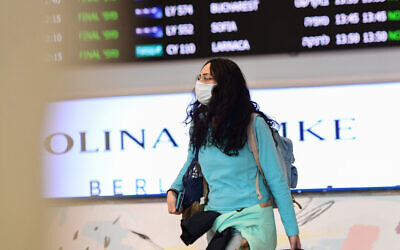 Les gens portent des masques à l'aéroport international Ben Gurionsuite à des informations sur le virus meurtrier apparu en Chine, qui s'est propagé dans le monde entier, le 17 février 2020 (Crédit :  Avshalom Shoshani/Flash90)