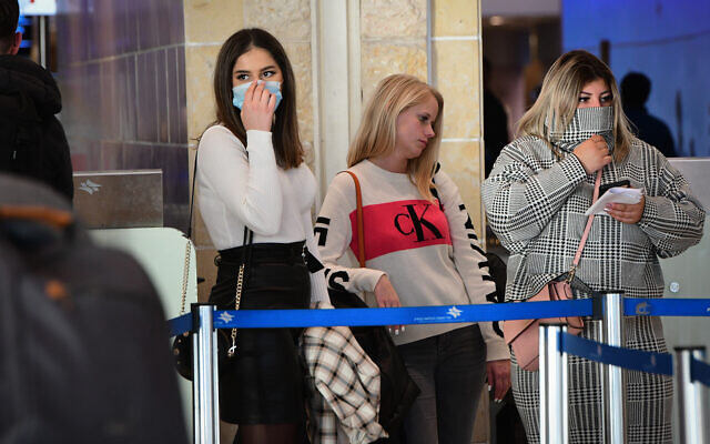 Des gens se couvrent le visage à l'aéroport international Ben Gurion par crainte du coronavirus, le 2 février 2020. (Avshalom Shoshani/Flash90) Des gens se couvrent le visage à l'aéroport international Ben Gurion par crainte du coronavirus, le 2 février 2020. (Avshalom Shoshani/Flash90)