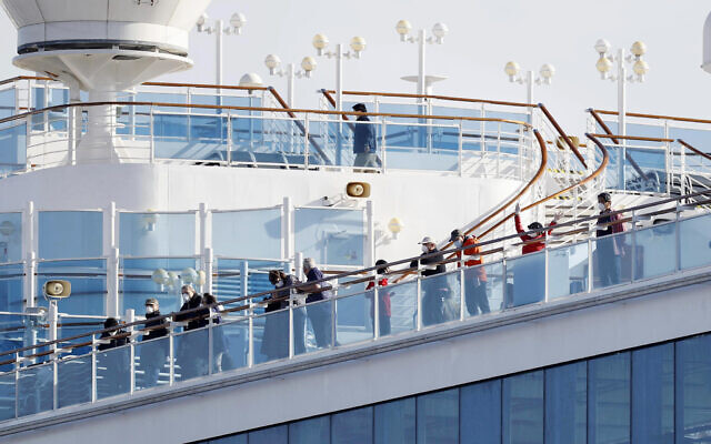 Des passagers sont sur le pont du bateau de croisière Diamond Princess amarré dans le port de Yokohama à Yokohama, non loin de Tokyo, le mercredi 12 février 2020. (Yuta Omori/Kyodo News via AP)