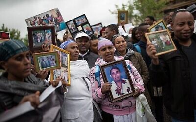 Des Israéliens qui ont immigré d'Ethiopie montrent des photos de famille de leurs proches restés en Ethiopie, lors d'une manifestation à Jérusalem pour faire venir le reste des Falashmura, le 20 mars 2016. (Corinna Kern/Flash90) Des Israéliens qui ont immigré d'Ethiopie montrent des photos de famille de leurs proches restés en Ethiopie, lors d'une manifestation à Jérusalem pour faire venir le reste des Falashmura, le 20 mars 2016. (Corinna Kern/Flash90)