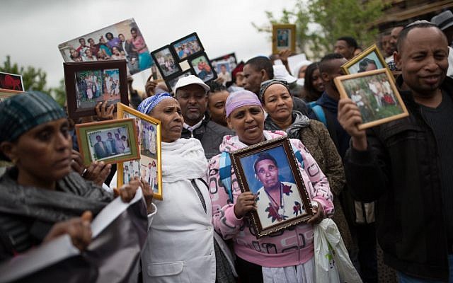 Des Israéliens qui ont immigré d'Ethiopie montrent des photos de famille de leurs proches restés en Ethiopie, lors d'une manifestation à Jérusalem pour faire venir le reste des Falashmura, le 20 mars 2016. (Corinna Kern/Flash90) Des Israéliens qui ont immigré d'Ethiopie montrent des photos de famille de leurs proches restés en Ethiopie, lors d'une manifestation à Jérusalem pour faire venir le reste des Falashmura, le 20 mars 2016. (Corinna Kern/Flash90)