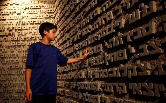 "Chaque personne a un nom". Un garçon touche les noms des victimes de l'Holocauste (Crédit : Flash90) "Chaque personne a un nom". Un garçon touche les noms des victimes de l'Holocauste (Crédit : Flash90)