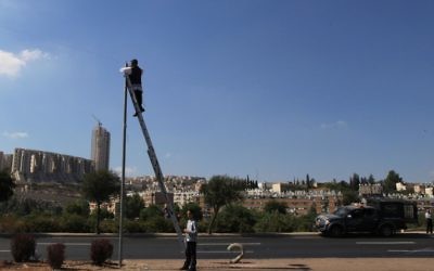 Illustration : Un homme vérifiant à l'ancienne un erouv, à Jérusalem. (Crédit : Nati Shohat/Flash90)