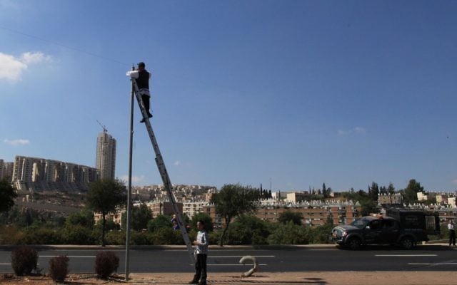 Illustration : Un homme vérifiant à l'ancienne un erouv, à Jérusalem. (Crédit : Nati Shohat/Flash90)