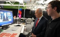 Le président Shimon Peres travaille sur sa page Facebook avec Mark Zuckerberg, fondateur de Facebook. (Crédit : Moshe Milner/GPO/Flash90)