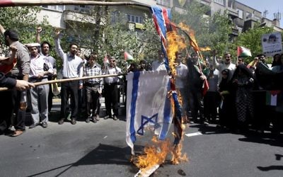 Iranian demonstrators burn an Israeli and British flag during an annual pro-Palestinian rally marking Quds (Jerusalem) Day, on the last Friday of the holy month of Ramadan, at the Enqelab-e-Eslami (Islamic Revolution) St. in Tehran, on Friday (photo credit: AP Photo/Vahid Salemi)