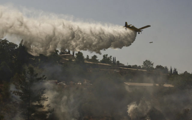 Les pompiers s'efforcent d'éteindre un incendie de forêt qui brûle près du Moshav Even Sapir. (Oren Nahshon/Flash90) Les pompiers s'efforcent d'éteindre un incendie de forêt qui brûle près du Moshav Even Sapir. (Oren Nahshon/Flash90)