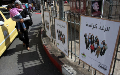 Une femme palestinienne passe à côté de posters électoraux à Ramallah, le premier jour de la campagne pour les élections municipales, le 6 octobre 2012. (Crédits : Issam Rimawi / Flash 90)