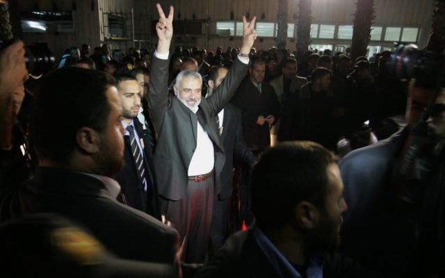 Les partisans du parti islamiste tunisien Ennahdha brandissent des drapeaux palestiniens pendant un discours d'Ismail Haniyeh, alors Premier ministre du Hamas dans la bande de Gaza, à Tunis, le 8 janvier 2012. (Crédit : Mohammed Al-Ostaz/Flash90)