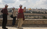 Tourists take pictures from the Mount of Olives, overlooking the walls of the Old City of Jerusalem and its distinctive golden Dome of the Rock. (photo credit: Yonatan Sindel/Flash90)