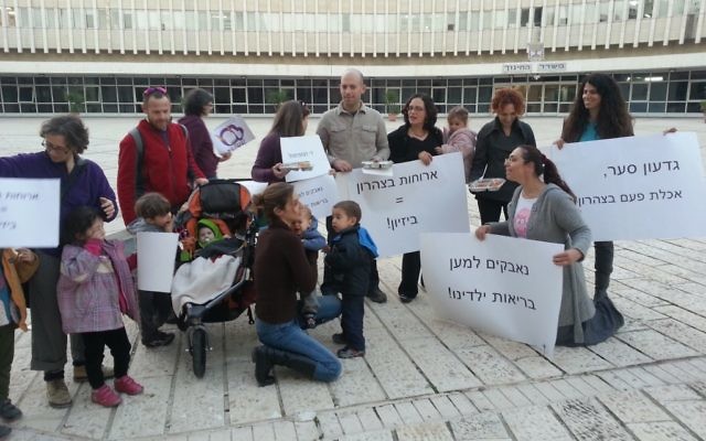Des membres de "Aruchat Eser" manifestent contre les déjeuners non sains des écoles en présentant des plateaux de nourriture au travailleurs du ministère de l'Education. (Crédit : Marik Stern) Des membres de "Aruchat Eser" manifestent contre les déjeuners non sains des écoles en présentant des plateaux de nourriture au travailleurs du ministère de l'Education. (Crédit : Marik Stern)