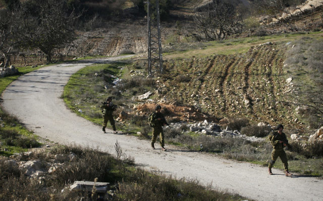 Des soldats de Tsahal patrouillent dans un champ situé près de Hébron. (Crédit : Michal Fattal/Flash90)