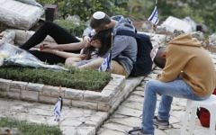 Des Israéliens se recueillent devant une tombe au cimetière militaire du mont Herzl à Jérusalem (Crédit photo: Miriam Alster / Flash90)