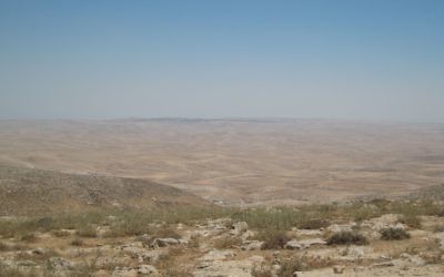 Le village palestinien de Jinba, au premier plan, près de la frontière de la zone de tir 918, avec la ville méridionale d'Arad à l'horizon. (Crédit : Ilan Ben Zion/Times of Israel staff)