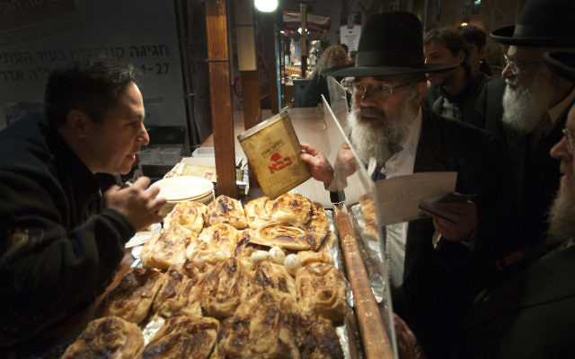 Un représentant du Grand Rabbinat inspecte un certificat de casheroute suspect dans un stand d'alimentation, Jérusalem, le 28 mars 2011. (Crédit : Rubin Salvadori/Flash90) Un représentant du Grand Rabbinat inspecte un certificat de casheroute suspect dans un stand d'alimentation, Jérusalem, le 28 mars 2011. (Crédit : Rubin Salvadori/Flash90)