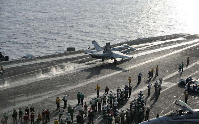 Un avion de combat décolle depuis le poste de pilotage du porte-avions de classe Nimitz USS Dwight D. Eisenhower en Méditerranée, en décembre 2012 (Crédit : CC BY-NC-ND Département américain de la Défense, Flickr) Un avion de combat décolle depuis le poste de pilotage du porte-avions de classe Nimitz USS Dwight D. Eisenhower en Méditerranée, en décembre 2012 (Crédit : CC BY-NC-ND Département américain de la Défense, Flickr)