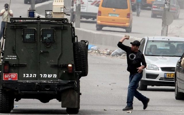 Des manifestants palestiniens jettent des pierres sur une voiture militaire israélienne pendant un rassemblement au checkpoint de Qalandiya, au nord de Jérusalem, le 20 mars 2013. Illustration. (Crédit : Issam Rimawi/Flash90) Des manifestants palestiniens jettent des pierres sur une voiture militaire israélienne pendant un rassemblement au checkpoint de Qalandiya, au nord de Jérusalem, le 20 mars 2013. Illustration. (Crédit : Issam Rimawi/Flash90)