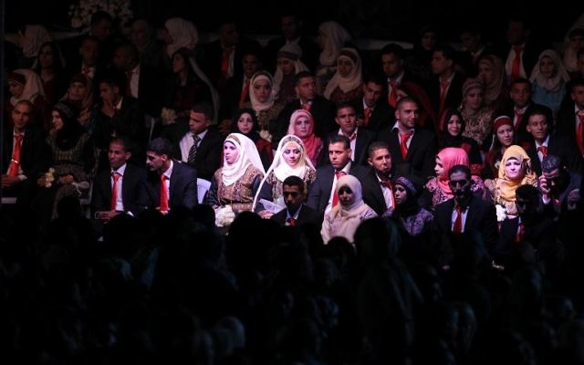 Des couples palestiniens lors d'une cérémonie collective de mariages, le 28 janvier 2014 à Jéricho 
(Crédit : AFP/Abbas Momani)