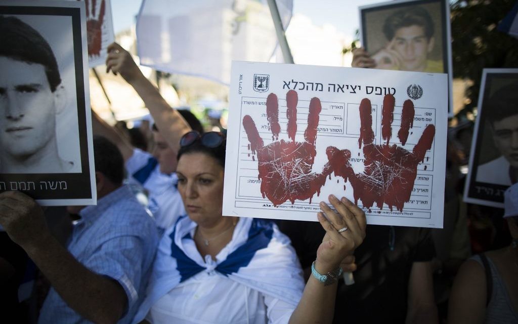 Manifestants israéliens protestant contre la libération de prisonniers palestiniens en août 2013. Il est écrit sur la pancarte : Formulaire de sortie de prison (Crédit : Flash 90) Manifestants israéliens protestant contre la libération de prisonniers palestiniens en août 2013. Il est écrit sur la pancarte : Formulaire de sortie de prison (Crédit : Flash 90)