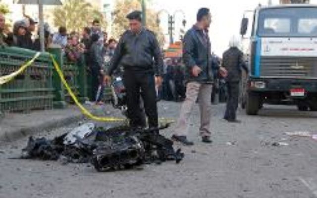 Des policiers et habitants sur les lieux d'un attentat à la voiture piégée devant le quartier général de la police, le 24 janvier 2014 au Caire. (Crédit: AFP/Khaled Kamel) Des policiers et habitants sur les lieux d'un attentat à la voiture piégée devant le quartier général de la police, le 24 janvier 2014 au Caire. (Crédit: AFP/Khaled Kamel)