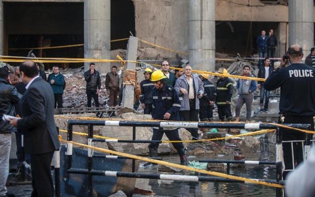 Des équipes de secours et des habitants sur les lieux d'un attentat visant le quartier général de la police, le 24 janvier 2014 au Caire (Crédit : AFP/Mahmoud Khaled) Des équipes de secours et des habitants sur les lieux d'un attentat visant le quartier général de la police, le 24 janvier 2014 au Caire (Crédit : AFP/Mahmoud Khaled)