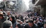 La file interminable de réfugiés lors d'une distribution de nourriture organisée par l'ONU, dans les ruines du camp de réfugiés de Yarmouk, au sud de Damas (Crédit : AFP Photo/HO/UNRWA)