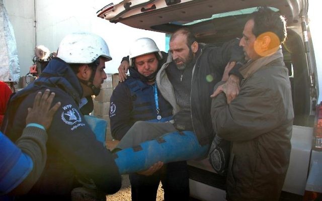 Un Syrien blessé évacué des quartiers assiégés de Homs, le 12 février 2014 lors d'une opération humanitaire (Crédit : AFP)