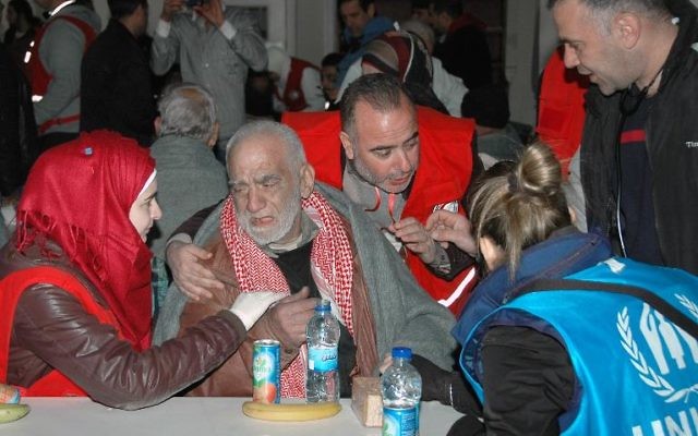 Des civils reçoivent de l'aide alimentaire à Homs le 7 février (Crédit : Sana/AFP)