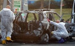 Des policiers enquêtent sur le véhicule, alors qu'une bombe a explosé dans la ville de Petach Tikva (Crédit :    Gideon Markowicz/Flash90)