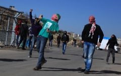 Des étudiants de l'université de Bir Zeit lancent des pierres vers l'armée israélienne près de Ramallah, 30 janvier 2014 (Crédit : Issam Rlmawi/Flash90)